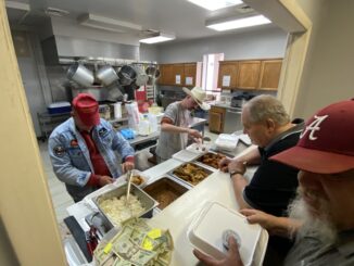 Tom Allan (left) and Clayton Luce (right, behind the counter) serve up slaw, beans, hushpuppies and more to hungry attendees at the First Baptist Church of Raeford Brotherhood Fish Fry last Friday. The event saw more than 500 pieces of fish served, raising some $2,500 for the Church. (Hal Nunn / North State Journal)