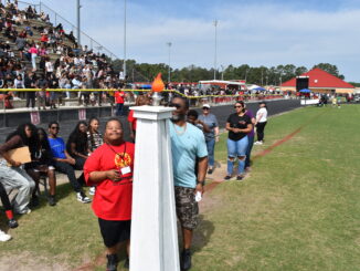 Hoke County Schools held its annual Special Olympics event on Friday at Raz Autry Stadium. This was the first full Special Olympics since 2020, with more 90 student athletes competing and more than 220 participating overall. Pictured is Jalen Bowers and his family bringing in the Special Olympics torch. Hal Nunn for North State Journal