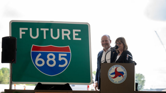 NC Transportation Board member Lisa Mathis and Transportation Secretary Joey Hopkins stand next to a Future I-685 sign. PJ Ward-Brown / North State Journal